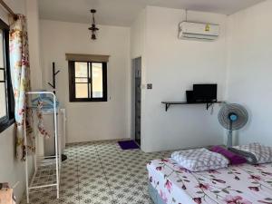 1 dormitorio con 1 cama, ventana y ventilador en grandmabalcony, en Prachuap Khiri Khan