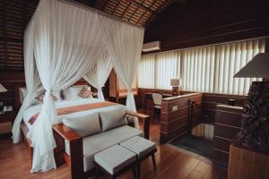 1 dormitorio con cama con dosel y silla en Amazing 1 Bedroom Villa in Ubud en Ubud