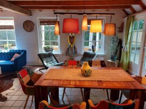 een woonkamer met een houten tafel en stoelen bij Zentopia: vakantiehuis met wellness en meer. in Hulshorst