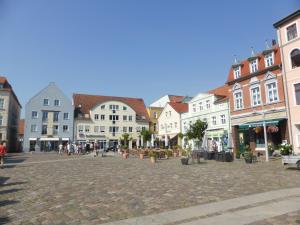 a town square with buildings and people walking around at Ferienhaus Anna in Neuendorf