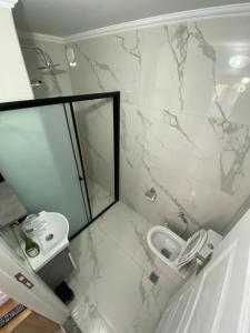 a white bathroom with a toilet and a shower at Menekşe Apart 1 in Trabzon