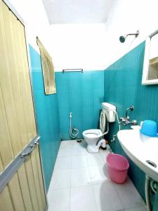 een blauwe badkamer met een toilet en een wastafel bij Aryan guest house in Bodh Gaya