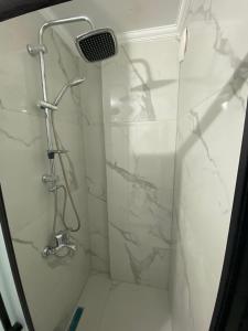 Un baño con ducha con paredes de mármol blanco. en Menekşe Apart 1, en Trabzon