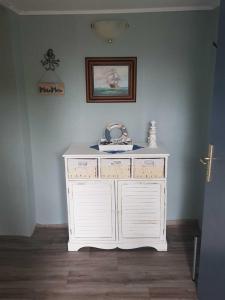 a white dresser in a corner of a room at Ferienwohnung Klabunde in Eggesin