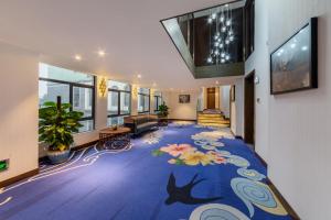 a lobby with a blue carpet with flowers on it at Overseas Chinese Town Nanyang Inn in Shenzhen