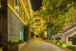 an alleyway in a building with trees and plants at Overseas Chinese Town Nanyang Inn in Shenzhen
