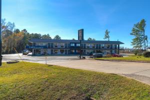 a large building with a parking lot in front of it at Xpress Inn & Extended Stay in Marshall