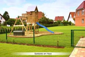 un parque infantil con un tobogán azul en un patio en Ferienwohnung "Hafftraum", en Liepgarten