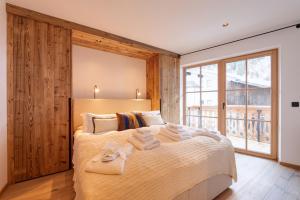 een slaapkamer met een groot bed en handdoeken bij Chalet Marmotta CULM - Luxus Chalet Ski-In Ski-Out in Sankt Anton am Arlberg
