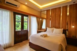 een slaapkamer met een groot wit bed in een kamer bij AB Hotel Kuta in Kuta