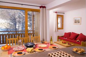 a living room with a table with food on it at Madame Vacances Les Balcons Des Airelles in Les Orres