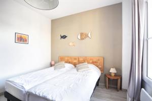 Un pat sau paturi într-o cameră la Les Sables Dor - Joli T3 200m de la plage