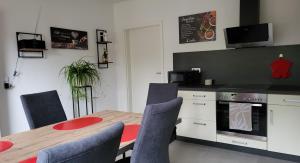 uma cozinha com mesa e cadeiras e uma cozinha com fogão em Ullas Gästehaus em Munster im Heidekreis