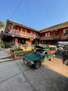 a green truck parked in front of a building at Shin Sane Guest House in Mae Salong