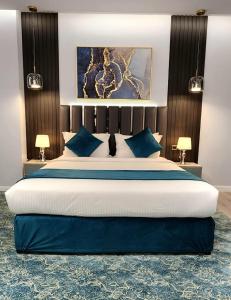 a bedroom with a large bed with blue pillows at Qasr Al Sahab in Khamis Mushayt
