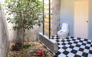 a bathroom with a toilet and a black and white checkered floor at Bangnu Greenery Resort in Takua Thung