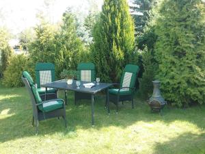a table and four chairs sitting around a table and sidx sidx sidx at Ferienhaus Emma Ferienwohnung "Paul" in Berndshof