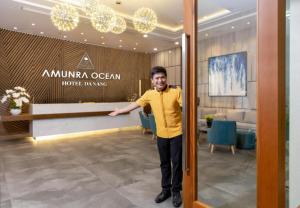 a man is standing in a hotel lobby at Amunra Ocean Hotel in Da Nang