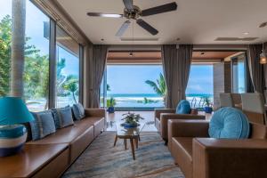 a living room with couches and a large window at KOI Resort & Residence Da Nang in Da Nang