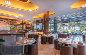 ダナンにあるKOI Resort & Residence Da Nangのテーブルと椅子がたくさんあるレストラン