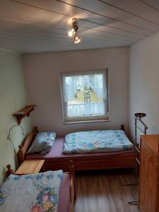 1 dormitorio con 2 camas y ventana en Ferienhäuser - Unter den Kiefern NR 23 oder Nr 27, en Marienfelde