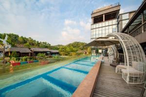 uma piscina num resort com um guarda-sol em Little Hakka Hotel em Shenzhen
