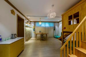 Habitación con escalera y cocina con mesa. en Little Hakka Hotel, en Shenzhen