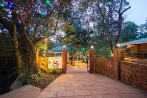 Una pasarela con una puerta y árboles por la noche en Scarlet Resort, en Matheran