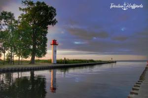 un faro seduto accanto a un corpo d'acqua di Ferienwohnung "Küstenliebe" a Ueckermünde