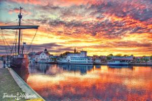 un tramonto su un porto con barche in acqua di Ferienwohnung "Küstenliebe" a Ueckermünde
