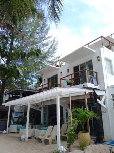 a house on the beach with chairs and trees at Signature Boracay South Beach in Boracay