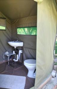 a bathroom with a sink and a toilet in a tent at Riverbend Camp - Self-catering Luxury Glamping Tent in Christiana