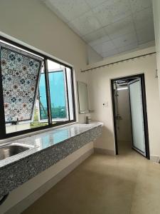 a bathroom with a sink and a large window at Hưng Thành Riverside Hotel in Thái Bình