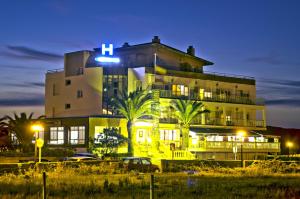a large building with palm trees in front of it at Hotel Costa de Ajo in Ajo