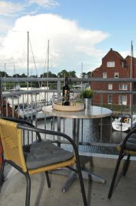 a table and chairs on a balcony with a marina at FEWO Seestern 231 in der Lagunenstadt in Neuendorf