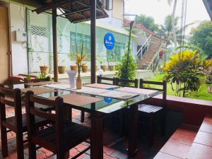 a wooden table and chairs on a patio at The RiverBells -An Island Stay in Alleppey