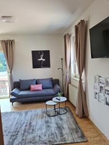 a living room with a blue couch and a table at Charmante Wohnung in Pregarten in Pregarten