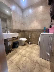 a bathroom with a toilet and a sink at WhiteFort apartment in Almaty +10 photos
