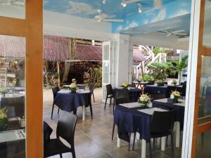 a restaurant with tables and chairs with blue tables at Signature Boracay South Beach in Boracay