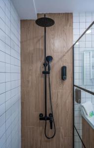 La salle de bains est pourvue d'une douche et d'une porte en bois. dans l'établissement New Gudauri Cozy Apartment with a Mountain View, à Goudaouri