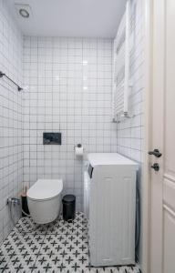 La salle de bains est pourvue de toilettes et de carrelage noir et blanc. dans l'établissement New Gudauri Cozy Apartment with a Mountain View, à Goudaouri