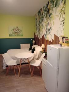 La cuisine est équipée d'une table, de chaises et d'un réfrigérateur. dans l'établissement chez lulu, à Saint-Saturnin-lès-Apt