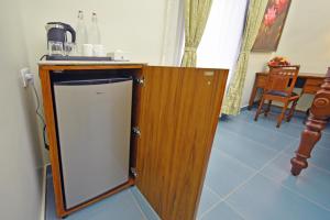 a kitchen with a counter with a sink and a refrigerator at Le Colonial Suites in Puducherry