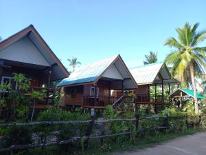 eine Reihe von Cottages mit Palmen im Hintergrund in der Unterkunft รายานี in Ko Por