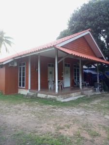 a small red house with a porch and chairs at Bilik Bajet RM70-RM90 in Kuala Terengganu