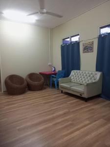 a living room with a couch and a table and blue curtains at Bilik Bajet RM70-RM90 in Kuala Terengganu