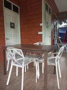 a wooden table and chairs on the porch of a house at Bilik Bajet RM70-RM90 in Kuala Terengganu