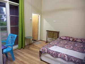 a bedroom with a bed and a chair and a window at Bilik Bajet RM70-RM90 in Kuala Terengganu