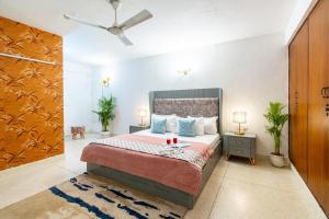 1 dormitorio con 1 cama y ventilador de techo en Homlee-Excellency 4BHK Apt in South Delhi, en Nueva Delhi