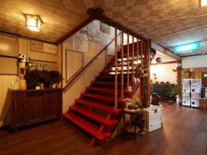 a staircase in a store with a red stair case at Hayamasou in Tokamachi